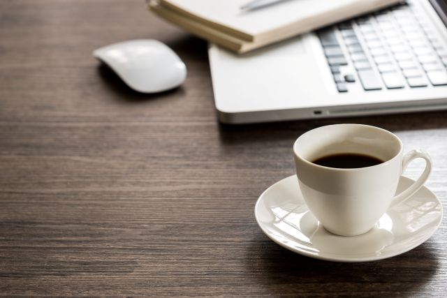 デスクに置かれたパソコンとコーヒーカップ